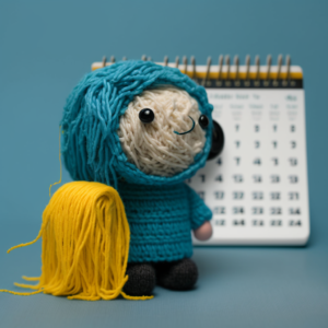 a person made out of yarn looking at a calendar, representing how sensory processing issues in autism affect an autistic person's daily life.